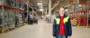 Frau steht in REWE Lagerhalle