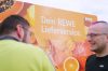 Mitarbeiter von REWE Lieferservice stehen vor Lieferwagen